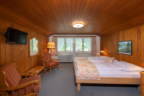a bedroom with a bed and a tv and a chair at CPM Apartments in Grindelwald
