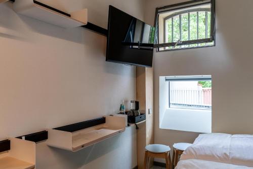 a room with a bed and a tv and a window at Das Kittchen in Wismar