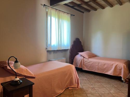 a bedroom with two beds and a window and a table at La Torre wine resort in Montecarlo