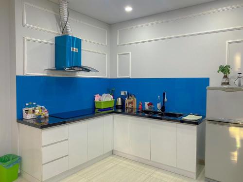 a kitchen with blue and white cabinets and a sink at Boom'homes- Căn hộ view Vịnh Hạ Long in Ha Long