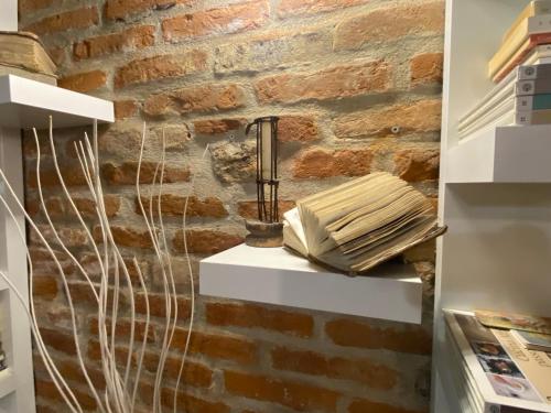 a room with a brick wall with a lamp at La Canonica di Soglio in Camerano Casasco