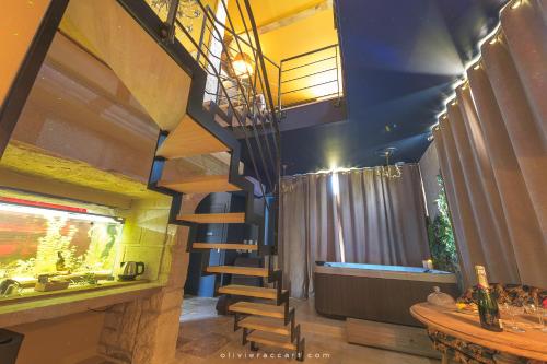 a living room with a spiral staircase and a fish tank at Chambres d'hôtes La Mascrabiere BED & SPA in Albi