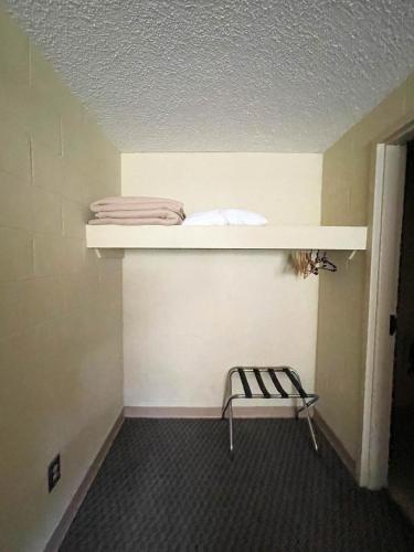 a room with a shelf and a chair on a wall at Hillside Lodge in Lake Junaluska