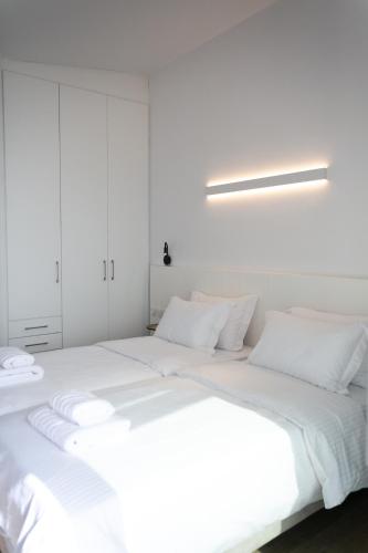 a large white bed with white sheets and pillows at Physis Fokida in Eratini
