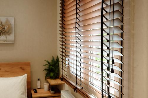 a bedroom with a window with wooden blinds at Serenity Hill in Veria