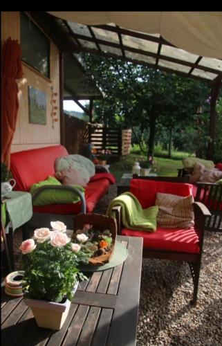 a patio with two couches and a table with a bowl of flowers at Orangerie Zimmer Gehaichnishof 7born in Maring-Noviand