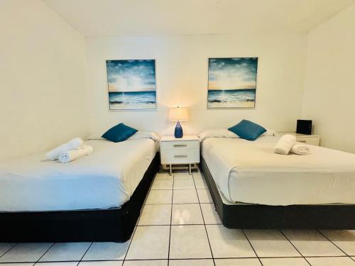 two beds sitting next to each other in a room at Sunrise Family Oasis Pool Lake Canal Views in Sunrise