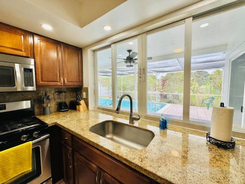 a kitchen with a sink and a large window at Sunrise Family Oasis Pool Lake Canal Views in Sunrise