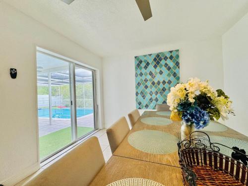 a dining room with a table with a vase of flowers at Sunrise Family Oasis Pool Lake Canal Views in Sunrise