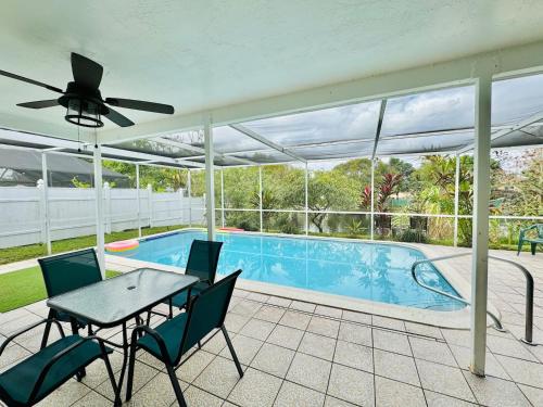a patio with a table and chairs and a swimming pool at Sunrise Family Oasis Pool Lake Canal Views in Sunrise