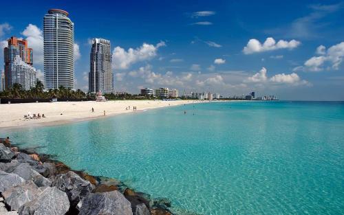 a beach with people and buildings in the background at Sunrise Family Oasis Pool Lake Canal Views in Sunrise