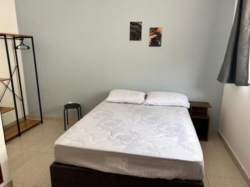 a bed with two pillows on it in a room at Morada Guest House in Balneário Camboriú