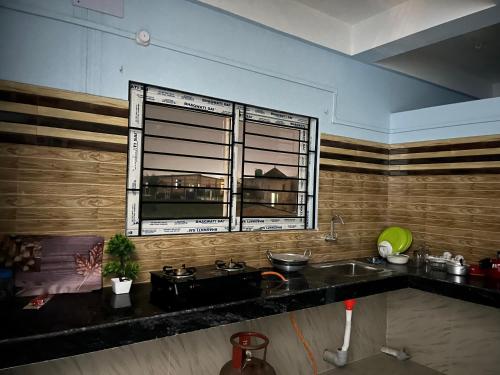 a kitchen with a sink and a window at Beltola serenity homestay in Guwahati