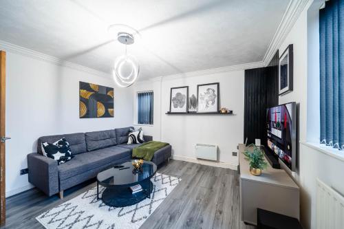 Una sala de estar con un sofá y un televisor. en COMFORTABLE SPARE ROOM with KING SIZE BED, Near Sheffield Centre, en Heeley