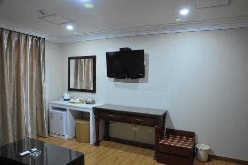 a room with a desk and a tv on the wall at Palace Hotel Gwangju in Gwangju