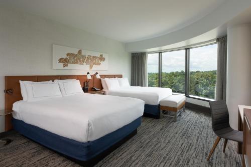 a hotel room with two beds and a window at Hilton Fairfax, Va in Fairfax