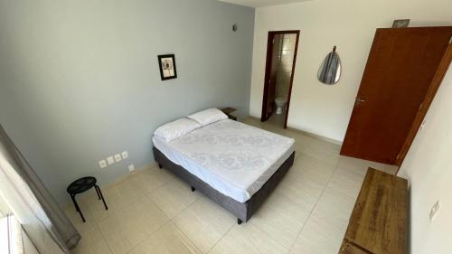 a bedroom with a bed in the corner of a room at Morada Guest House in Balneário Camboriú