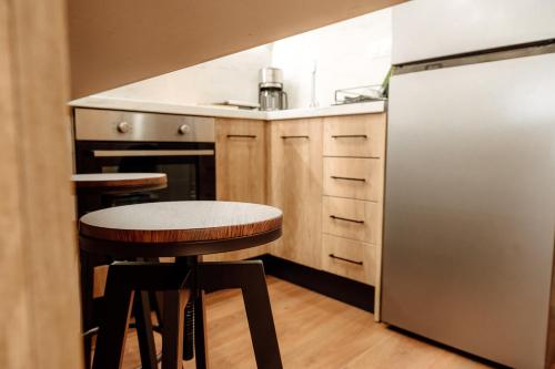 a kitchen with a refrigerator and a table and stools at The Clock House in Veria