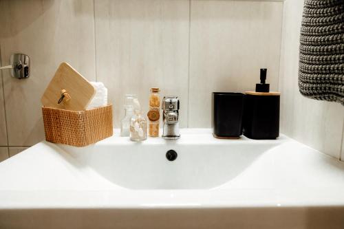 a bathroom sink with soap and a basket on it at The Clock House in Veria