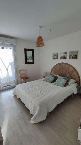 - une chambre avec un grand lit et un grand couvre-lit blanc dans l'établissement Rez de jardin, St Brevin les Pins, plage à pieds, à Saint-Brévin-les-Pins