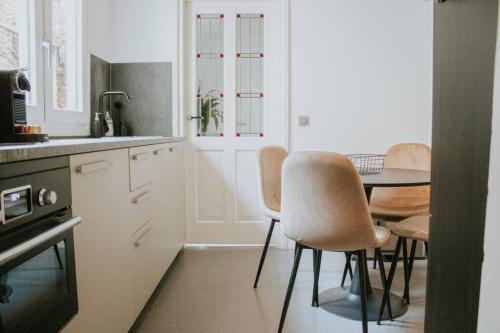 a kitchen with a table and chairs and a kitchen with white cabinets at 4P boetiek apt met tuin bij Fontys en klooster in Tilburg