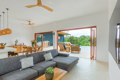 a living room with a gray couch and a table at Elegant Ocean View Villa Serena in Cóbano