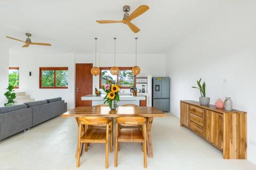 a kitchen and living room with a wooden table and chairs at Elegant Ocean View Villa Serena in Cóbano