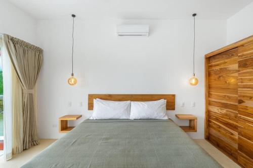a bedroom with a large bed and a window at Elegant Ocean View Villa Serena in Cóbano