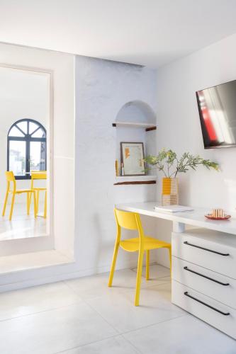 a kitchen with a yellow dining table and yellow chairs at Captain Hook in Hydra