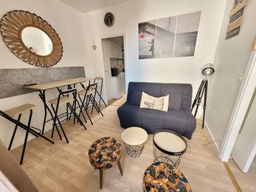 un salon avec un canapé bleu et une table dans l'établissement F1 hyper centre, à Clermont-Ferrand