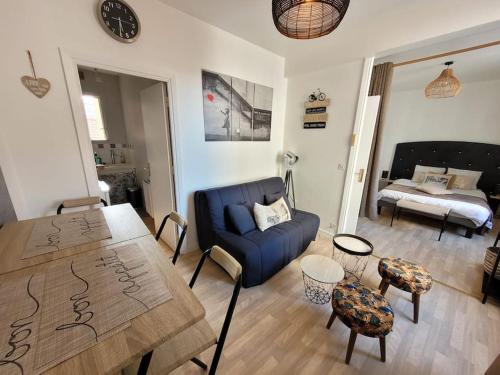 un salon avec un canapé bleu et une table dans l'établissement F1 hyper centre, à Clermont-Ferrand