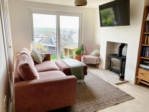 a living room with a couch and a fireplace at Cosy 3 bedroom home, 2 minutes from the beach in Perranporth