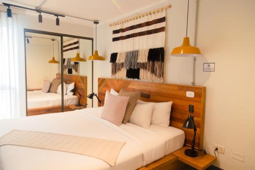 a bedroom with a large white bed and a mirror at Miraflores Apartments in Lima