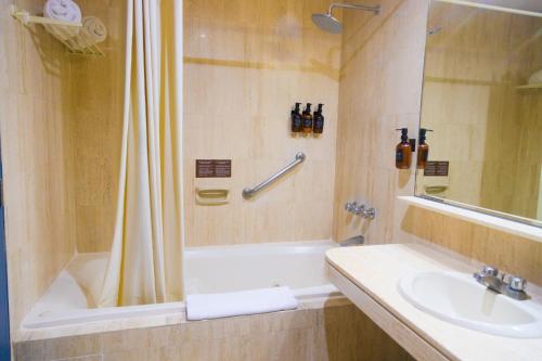 a bathroom with a tub and a sink and a shower at Miraflores Apartments in Lima