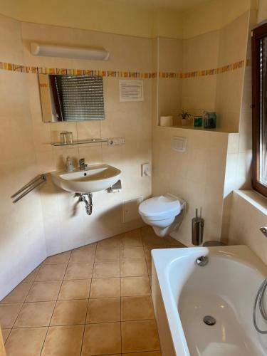 a bathroom with a tub and a sink and a toilet at Pension Spreewaldstube in Vetschau