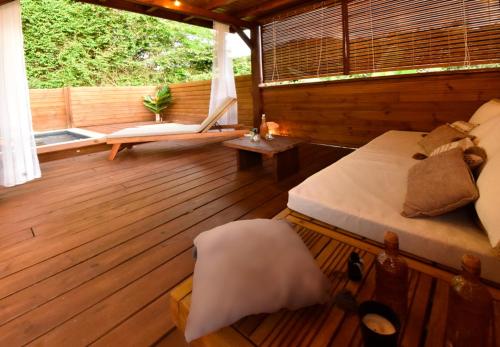 a bedroom with a bed on a wooden deck at Domaine de Ti Coin in Rivière-Salée