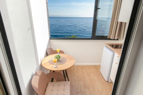 a small room with a table and a large window at Apartments Malina in Tučepi