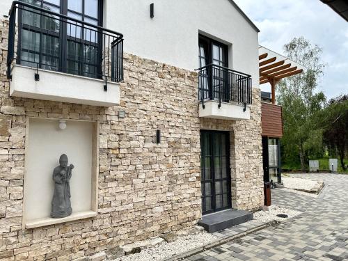 a statue on the side of a brick building at Szent Orbán Erdei Wellness Hotel és Residence in Kóspallag