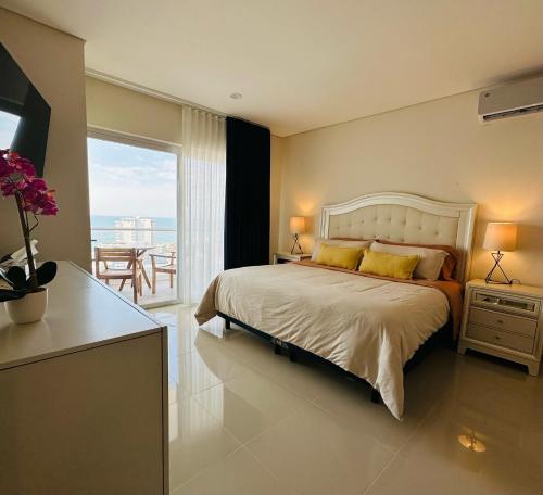 ein Schlafzimmer mit großem Bett und Balkon in der Unterkunft Lucero - Beach Condo in Mazatlán