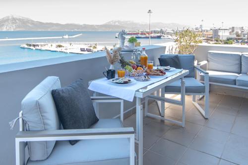 a table and chairs on a balcony with a view of the ocean at Majestic Penthouse in the heart of Patra in Patra