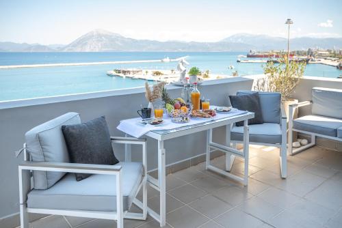 a table and chairs on a balcony with a view of the water at Majestic Penthouse in the heart of Patra in Patra