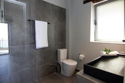 a bathroom with a toilet and a sink and a tub at Lithorama Residence Mani - First Floor in Koúmani