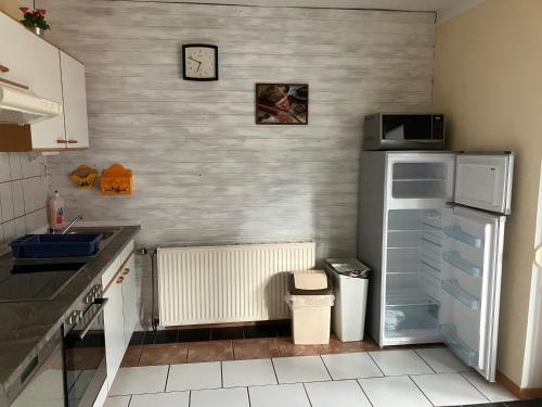 a kitchen with a refrigerator and a clock on the wall at Ferienwohnung Haus Cerny in Bad Goisern