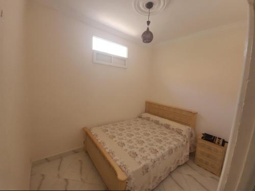 a small bedroom with a bed and a window at Luxury Cosy Apartment in Al Hoceima, Morocco in Al Hoceïma