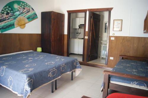 a bedroom with a blue bed and a mirror at Abbamala Village in Bosa