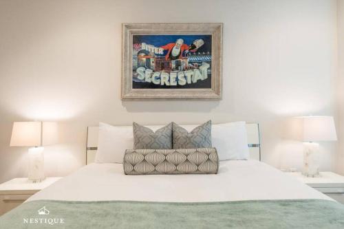 a bedroom with a white bed with a picture on the wall at Park Haus on Main Street in Historic Old Town Hosted by Nestique in Park City
