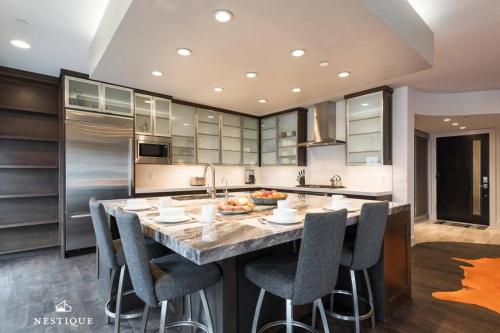 a kitchen with a large marble island with bar stools at Park Haus on Main Street in Historic Old Town Hosted by Nestique in Park City