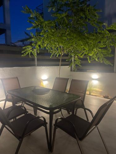 a table and chairs on a patio at night at Karamelas Vacation House in Nea Kalikratia