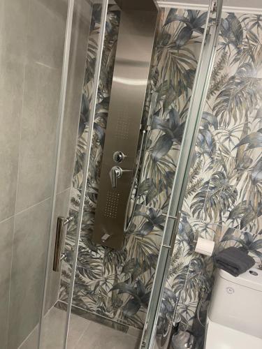 a shower with a glass door next to a toilet at Karamelas Vacation House in Nea Kalikratia