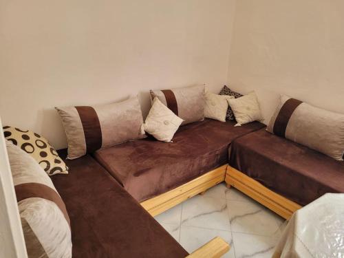 a brown couch in a room with pillows on it at Luxury Cosy Apartment in Al Hoceima, Morocco in Al Hoceïma